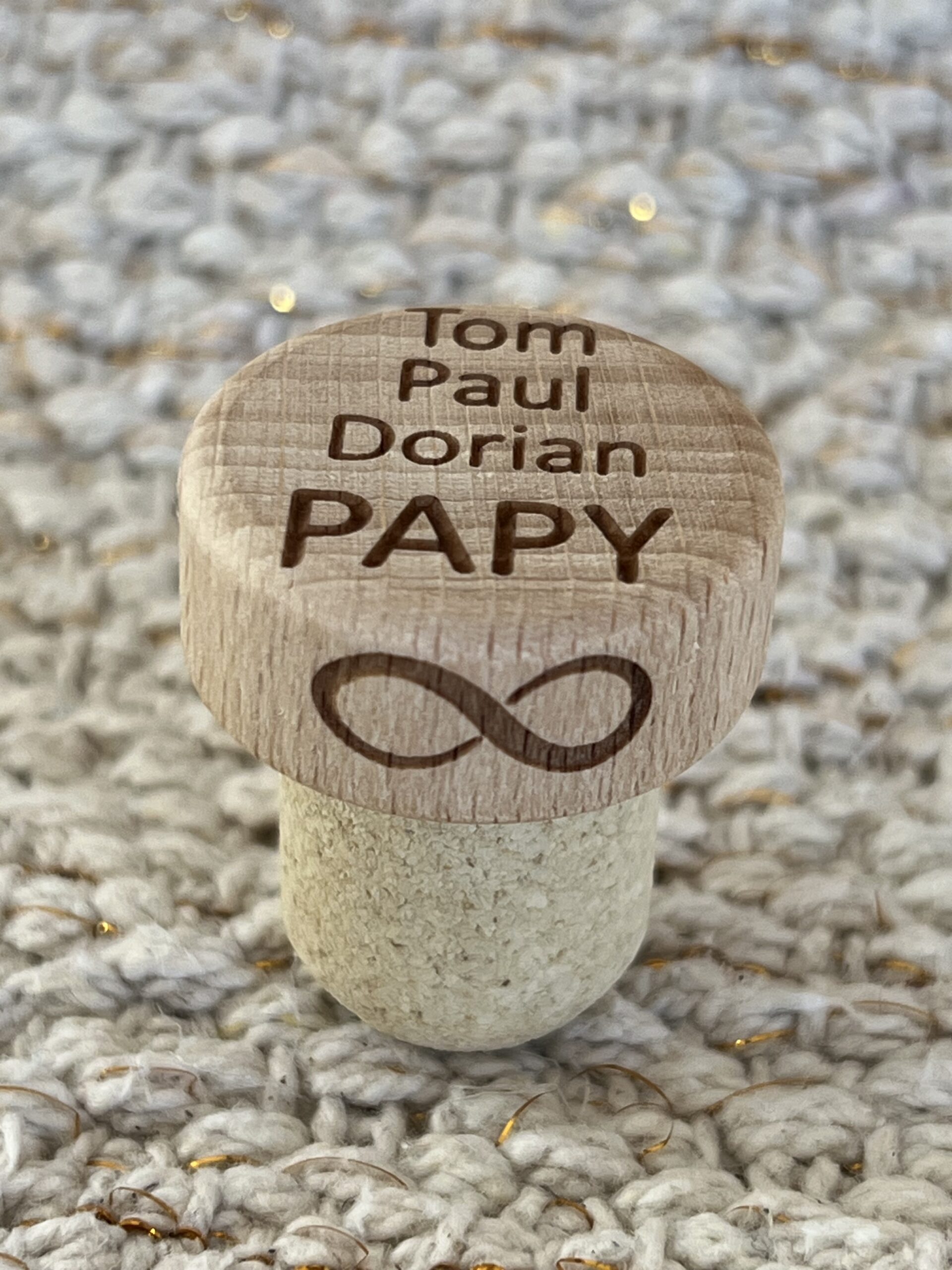 Bouchon de bouteille en bois personnalisé avec les noms des petits-enfants et un symbole d'affection pour leur grand-père, idéal comme cadeau ou souvenir
