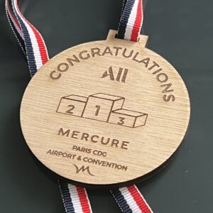 Médaille en bois personnalisable avec gravure et ruban tricolore, idéale pour récompenses ou événements.